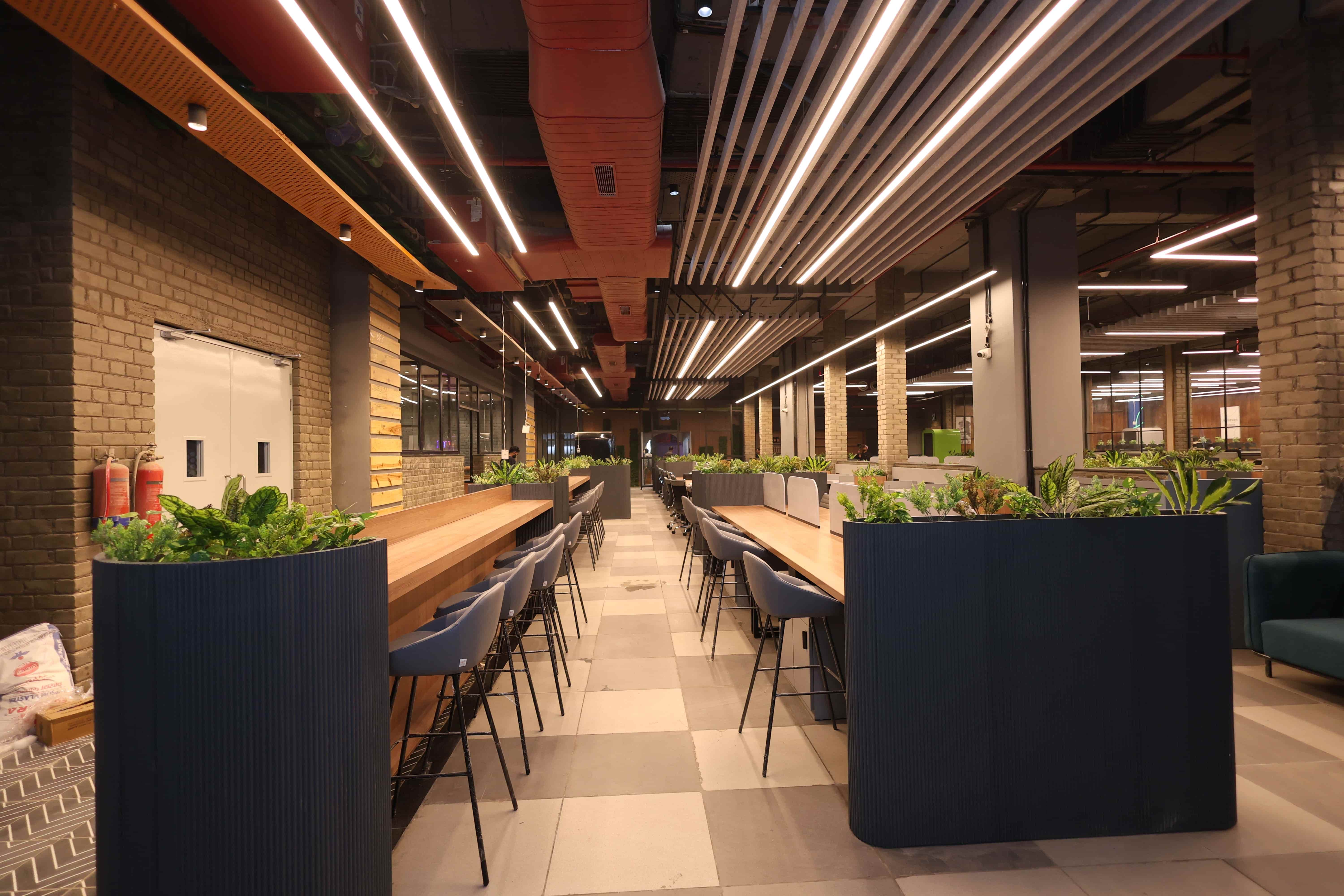 Warm modern coworking floor with long shared desk setup