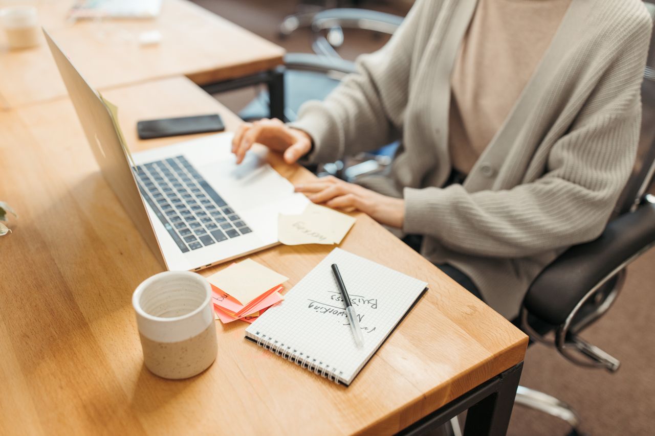 Minimal wooden desk setup with notepad and pen for productive startup work